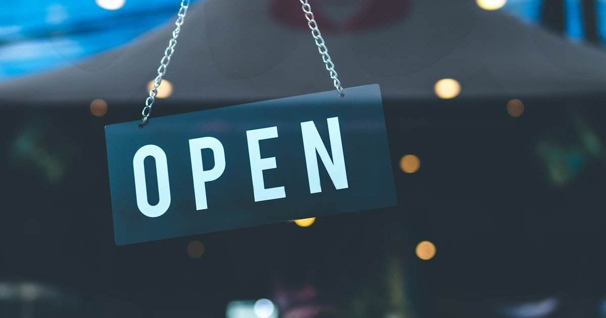 Open sign hanging in a small business storefront window